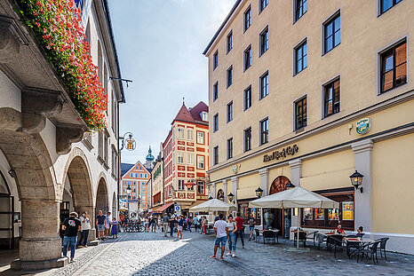 The photo shows a cobble stone road in Munich's city center on a sunny day