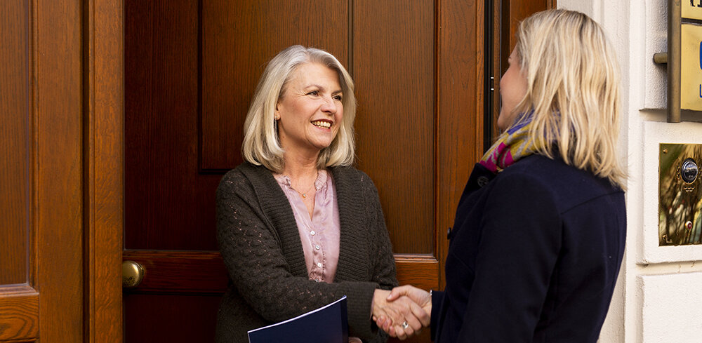 Two women shake hands.