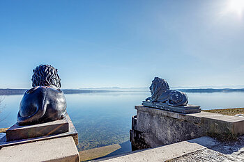 The photo shows lion statues overlooking the lake