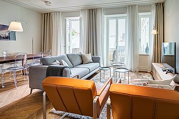 The photo shows a luxuriously furnished living room with floor-to-ceiling windows