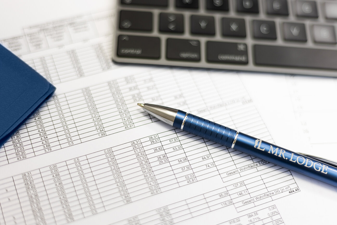 You can see a sheet with numbers, a pen and a keyboard 