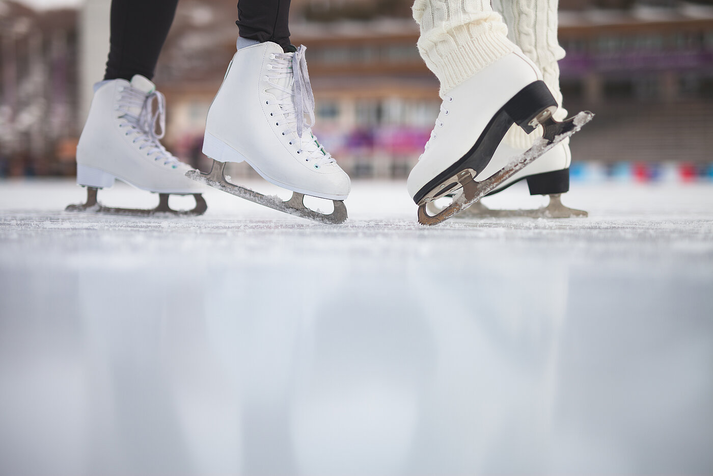 The photo shows two people ice-skating, the shot is cropped to show their ice-skates