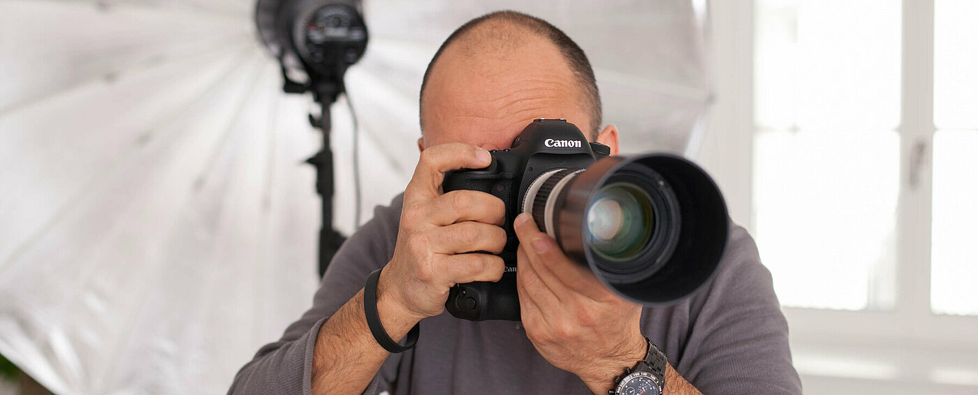 The picture shows a photographer with his camera for real estate photography.